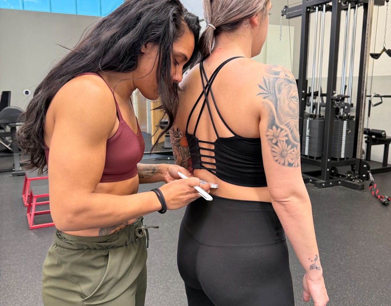 Coach Ashley giving individual attention to a client during an assessment in her training space